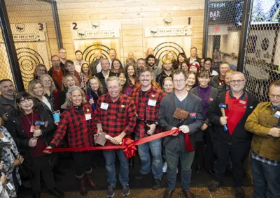 group of people doing a ribbon cutting at an axe throwing business