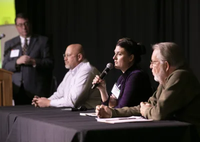 people on speaker panel on stage at an event