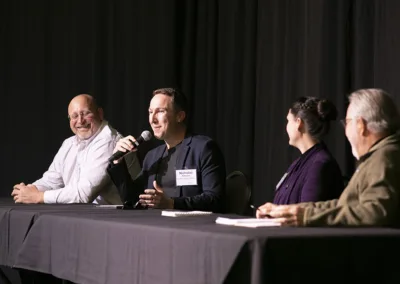 people on speaker panel on stage at an event