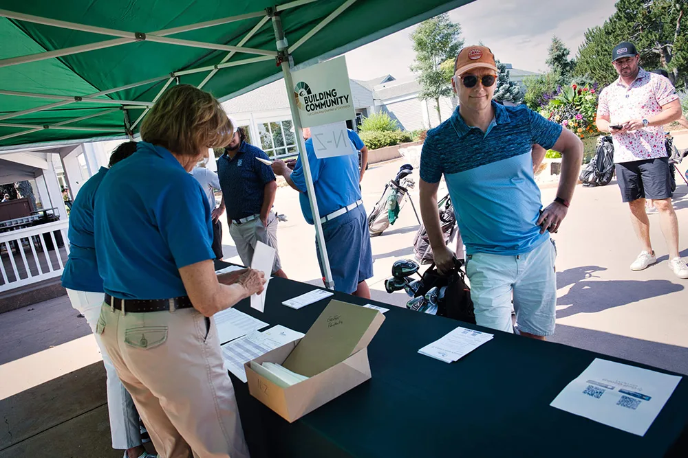person at golf event registering at a table