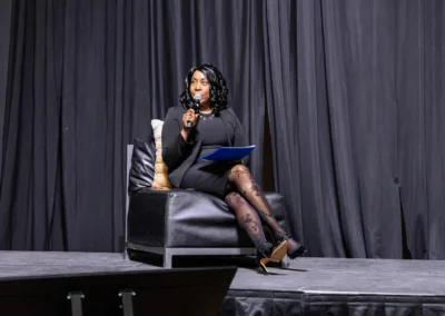 Woman sitting in a chair speaking into a microphone