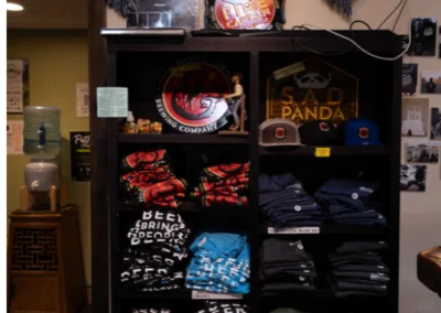 A merchandise shelf full of t-shirts and hats