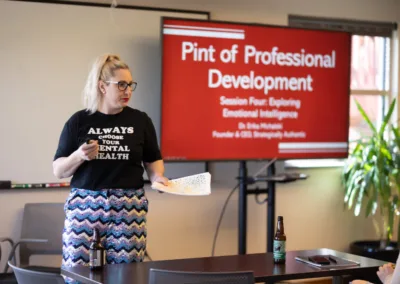 A woman standing next to a screen presenting