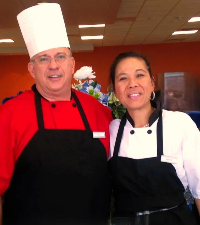 Man and women dressed as chefs smiling for a photo