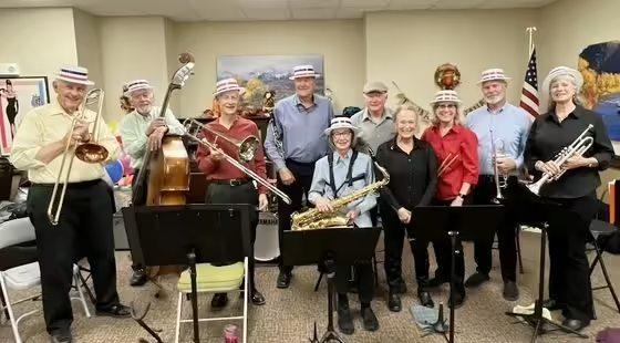 A group of musicians holding their instruments pose for a photo
