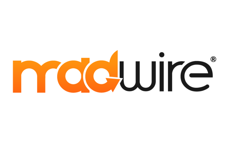 The image displays the Madwire logo. The text "mad" is written in bold, lowercase, orange letters, while "wire" is in bold, black, lowercase letters. The letter "a" in "mad" has an orange arrow integrated into its right side, pointing clockwise, connecting to the "d".