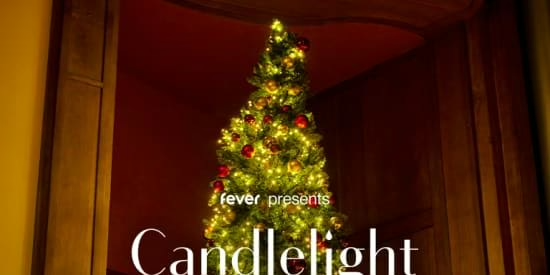 A Christmas tree adorned with twinkling lights and red ornaments stands in a dimly lit room. Text overlay reads, "Fever presents Candlelight.