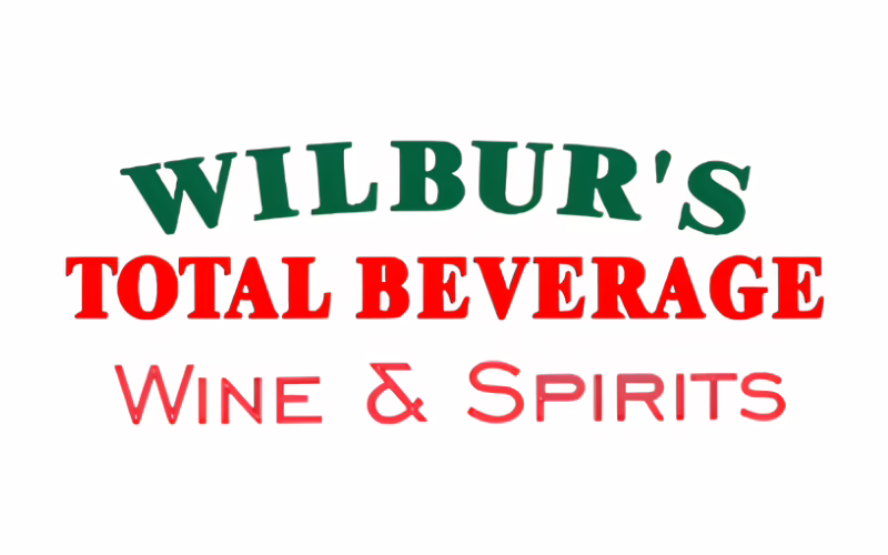 Logo with the words "WILBUR'S" in green, "TOTAL BEVERAGE" in red, and "Wine & Spirits" in pink, all on a white background.