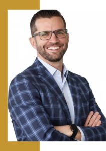 A man wearing glasses and a plaid jacket.