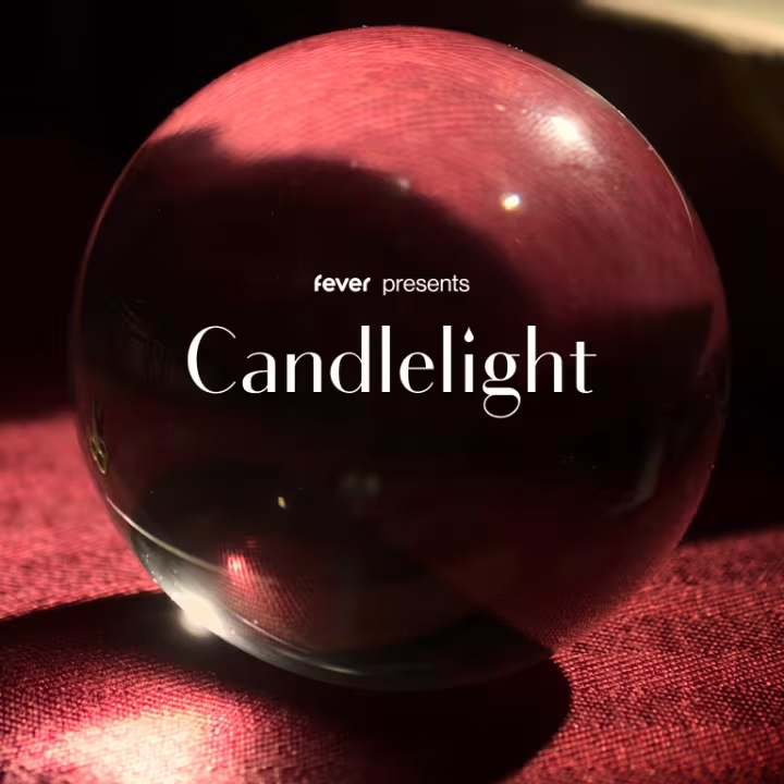 A glass sphere rests on a red textured surface with the text "fever presents Candlelight" overlaid, illuminated by soft, warm lighting.